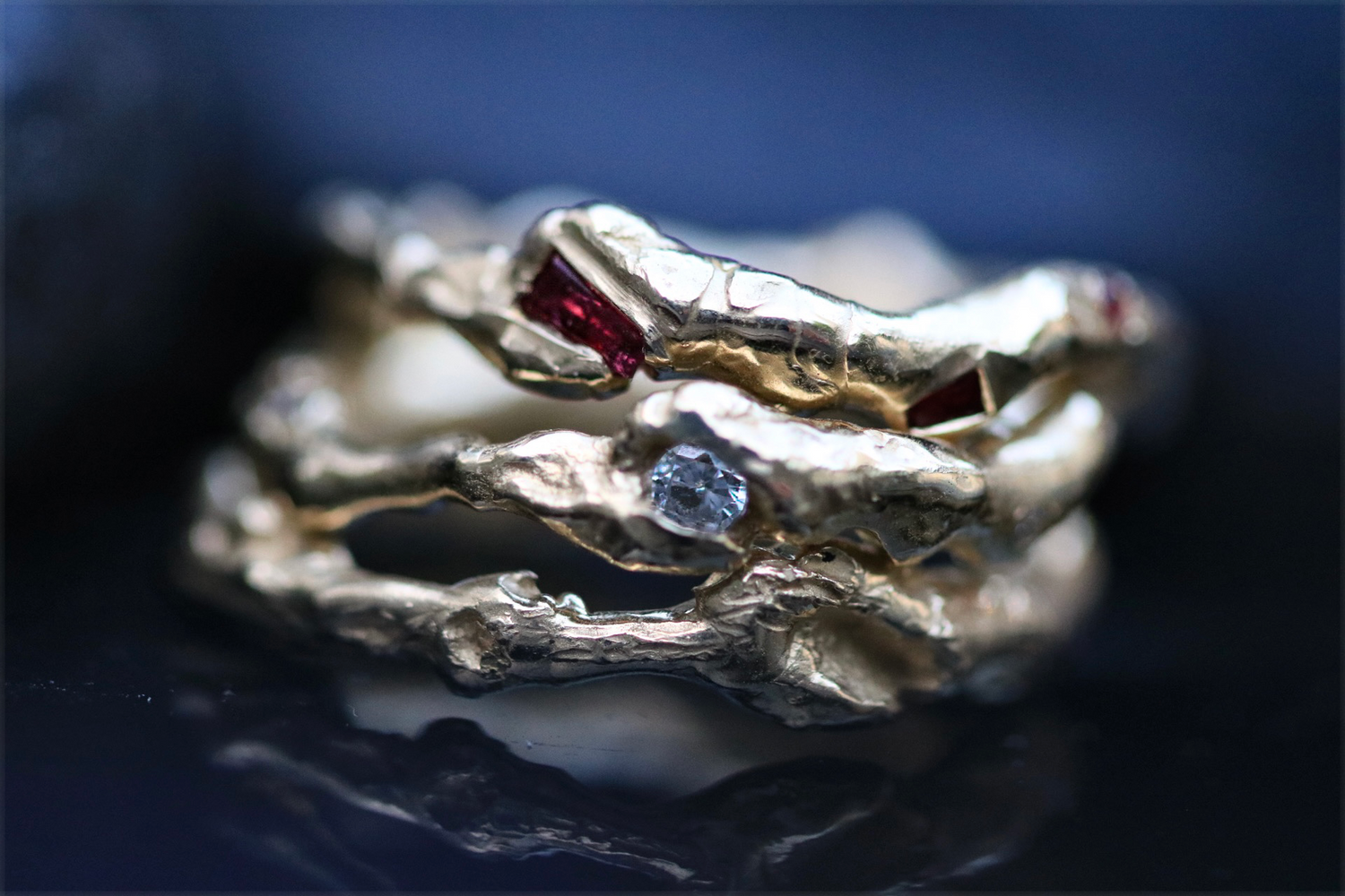 Close-up of handmade rings featuring unique gemstone settings and sparkling diamonds, showcasing artisanal craftsmanship and one-of-a-kind designs.